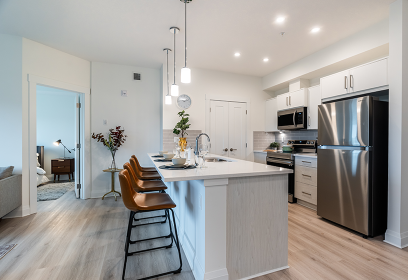 Open-concept kitchen with quarts countertops and stainless steel appliances.